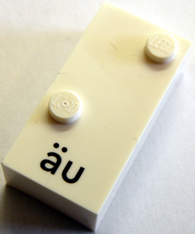 Brick, Braille 2 x 4 with 2 Studs with Black Lowercase Letters a with Diaeresis u (äu) Pattern (dots-34 ⠌) (German)