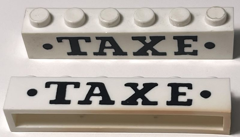 Brick 1 x 6 without Bottom Tubes with Cross Side Supports with Black 'TAXE' Serif Bold Large and Dots Pattern