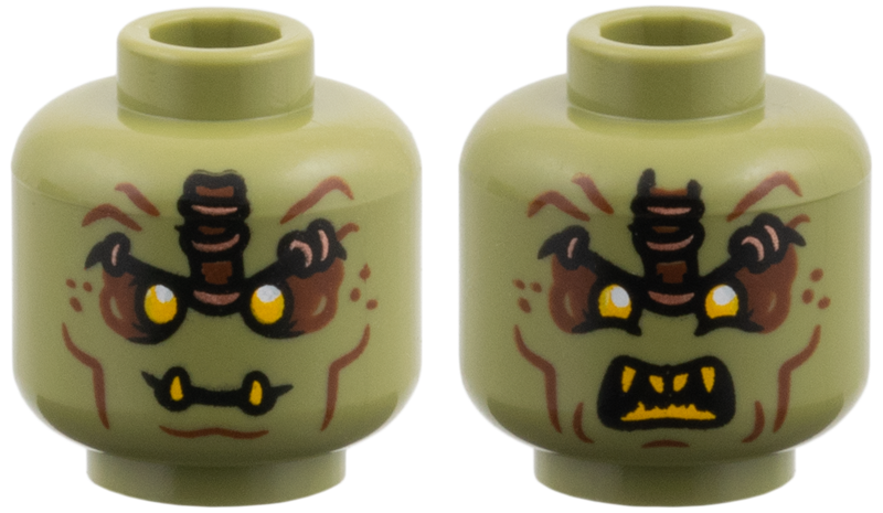 Olive green dual-sided alien head with bright orange eyes, wrinkles, and fangs in both a grin and an angry open mouth.