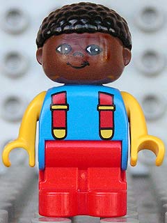 Duplo Figure, Child Type 1 Boy, Red Legs, Blue Torso with 2 Straps, Yellow Arms, Brown Head with Black Curly Hair
