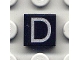 Lot ID: 55607365  Part No: 3070pb012  Name: Tile 1 x 1 with Silver Capital Letter D Pattern