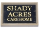 Part No: 26603pb456  Name: Tile 2 x 3 with Black Sign with Gold Scratched  'SHADY ACRES CARE HOME' Pattern (Sticker) - Set 76218